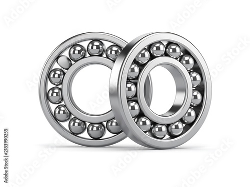 Plakat w ramie Metallic ball bearings stand aligned together over white surface.