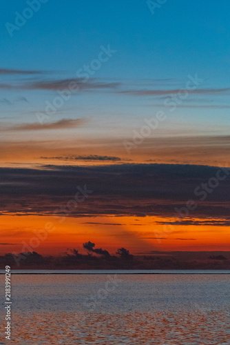 Bild auf Leinwand Orange and blue twilight sky above gently rippling Indian Ocean waters in the Maldives