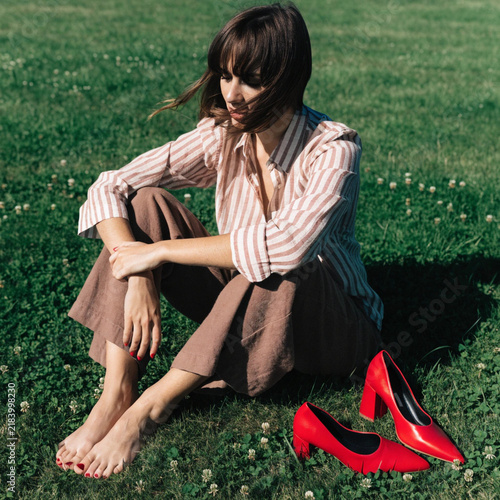 Barefoot Female Feet with Stylish Red Shoes in Nature
