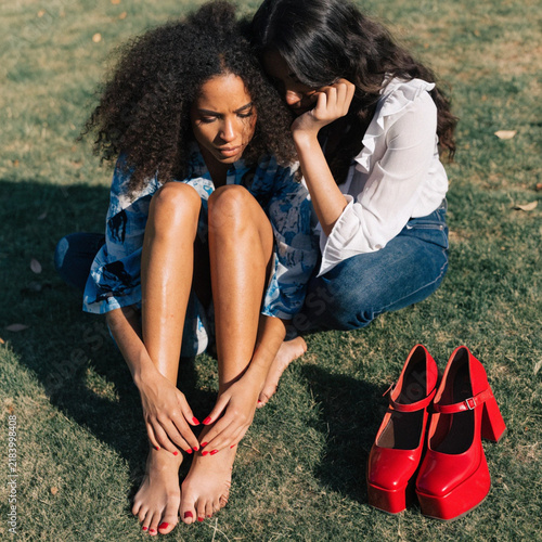 Barefoot Women with Red Shoes on Green Grass