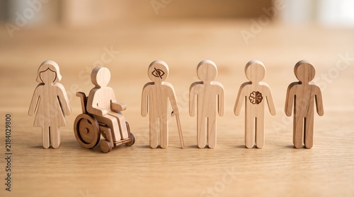 Wooden human figures standing together representing equality diversity and social inclusion