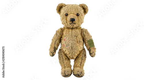 Bild auf Leinwand Vintage teddy bear with patches and worn fur, a beloved childhood toy