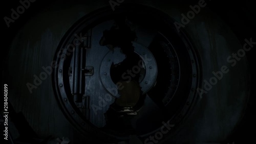Dolly in tracking shot of damaged metal vault door with gaping hole and crumbled debris inside underground industrial tunnel