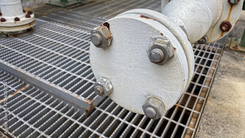 фотографія A metal pipe with a blank flange sealing the end in an industrial plant represen