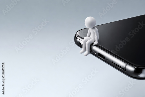 Small white figure sits on the edge of a smartphone. Space for text.