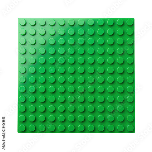 Vibrant green plastic toy building block baseplate with uniform grid of raised circular connection studs, isolated on transparent background with copy space. Concept of modularity and play