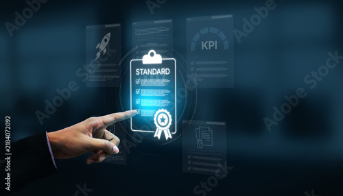 Фотография A business professional points at a digital standard document showcasing key performance indicators, symbolizing success and strategy in a modern office environment