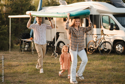 фотографія a young family is playing next to their mobile home