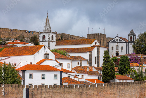 Panoramic cityscape of Obidos showing historic fortifications, white houses, and terracotta roofs - Portugal