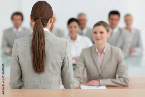 Job applicant sitting in front of a panel of interviewers in a bright modern office boardroom