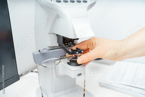 Quadro su tela A female optician measures and selects glasses using a state-of-the-art digital device at an optical store