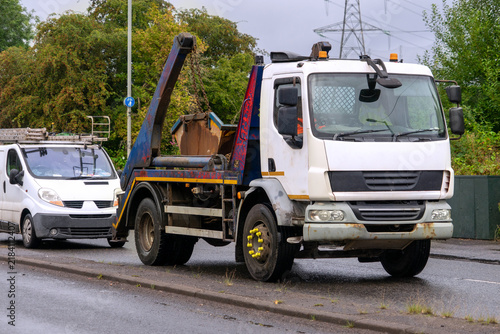 Obraz na płótnie Two commercial vehicles on an asphalt road during a gray, overcast day