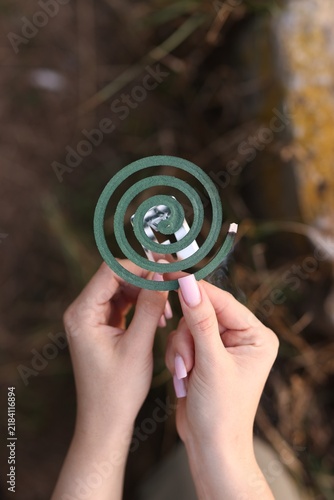Foto Woman with insect repellent coil outdoors, top view