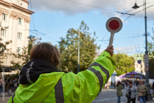 Konstfotografi Traffic marshal directing urban traffic with a handheld stop sign, road safety and temporary traffic control