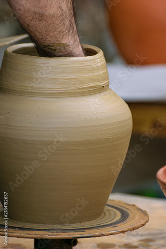 Potter shaping a wet clay vase on a wheel The Concept of traditional craftsmanship