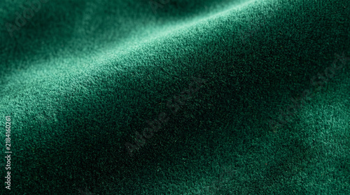 Deep emerald green velvet fabric texture background with soft light