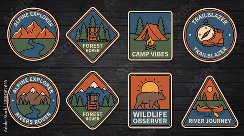 A collection of colorful outdoor adventure patches featuring mountains, forests, camping, and wildlife motifs on a wooden background.