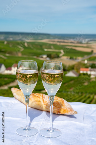 Champagne sparkling wine  tasting in glasses with view on Grand Cru Blanc de Blancs Chardonnay vineyards of Cramant, France.