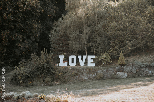Décoration de mariage en extérieur avec grandes lettres LOVE au cœur d'un jardin