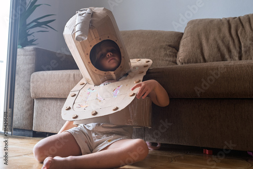 Bild auf Leinwand Girl Wearing a Homemade Cardboard Costume Looking Surprised Indoors