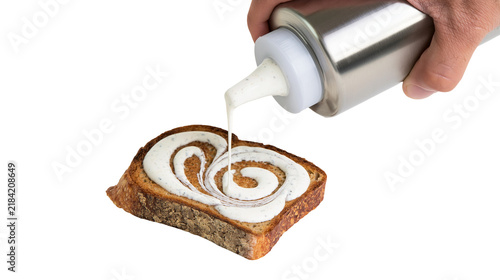 Canvas Print Isolated hand drizzling creamy garlic sauce onto rustic toasted bread creating a