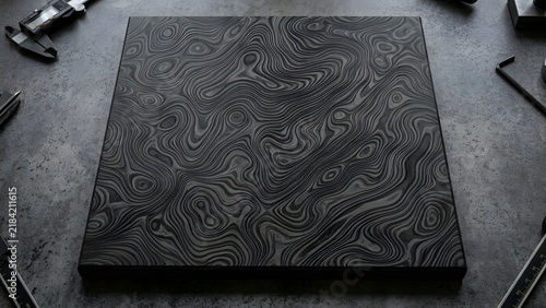 Obraz na płótnie Timascus slab featuring complex swirled Damascus titanium grain patterns on dark workshop bench