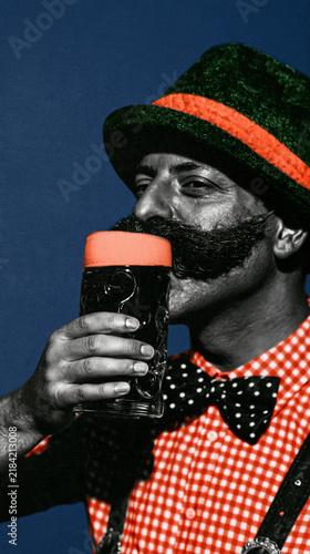 Man celebrating Oktoberfest, drinking a big beer mug, wearing a traditional Bavarian hat and gingham shirt