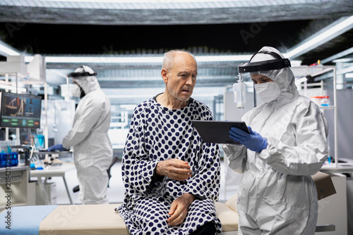 Принти на полотні Medical scientist examines isolated patient under biohazard conditions