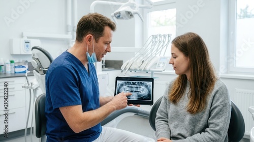 Dentist Explains Dental X-Rays To Patient On Tablet Modern Clinic