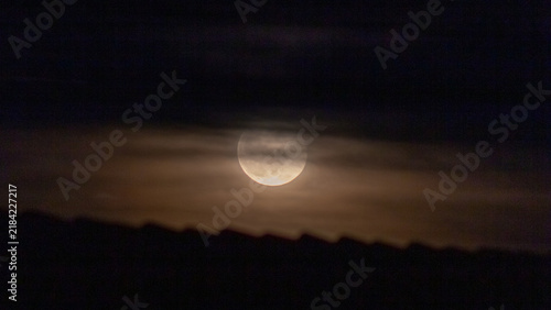 Fotografía Full moon in the night sky with clouds