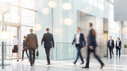 Business professionals walking through a modern glass entrance of a corporate building. Perfect for corporate brochures, business blogs, and web headers.