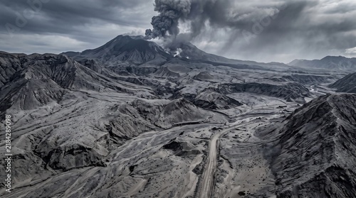 aerial view of volcanic ash landscape, vast terrain covered with gray and black ash after a powerful eruption, rugged volcanic textures and smoke rising in the distance, ultra realistic drone