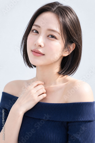Plakat ブルーグレー背景で微笑むショートボブの女性を写した透明感あるナチュラル美容ポートレート