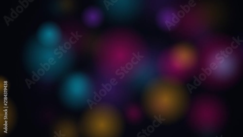 Abstract colorful bokeh lights background with soft glowing circles on dark backdrop.