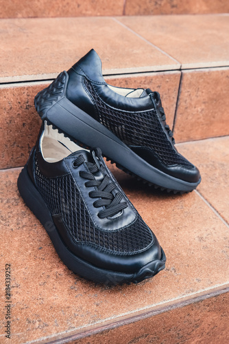 Elegant black leather womens shoes blank product for branding displayed. New casual female sneakers no-brand footwear e-commerce. No logo product unbranded fashion