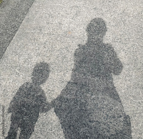 Obraz na płótnie 手をつないで公園まで歩く親子の影