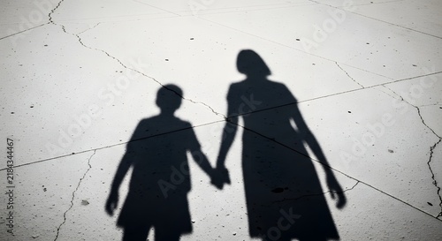 Mother and Child Shadow Silhouettes Walking Hand in Hand on Bright Pavement, Minimal Family Concept of Love and Togetherness