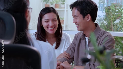 Asian couple having medical consultation and diagnosis with woman doctor, couple smiling looking at laptop screen with successful fertility pregnancy planning, counseling and checkup in clinic office.