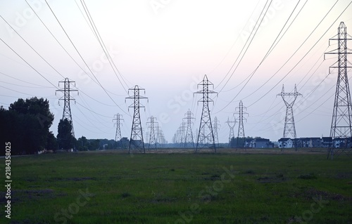 Canvastavla Electricity transmission towers and power lines extending across an open field, creating an industrial landscape at dusk
