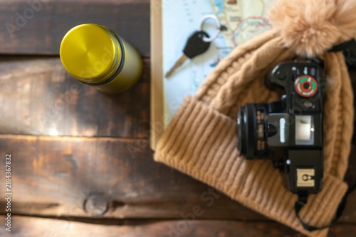 A bird's-eye view of items for a nature hike: a map, a camera, a wool hat, and a metal water bottle