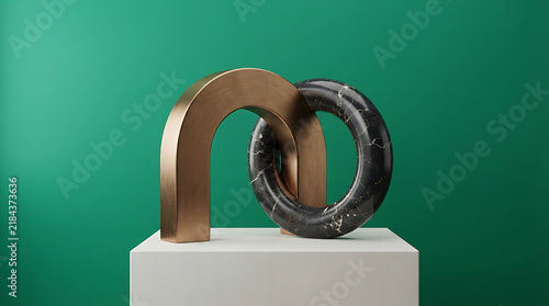 Abstract sculpture featuring a polished bronze arch interlocked with a black marble ring, displayed on a white pedestal against a solid green background, representing balance and geometric harmony