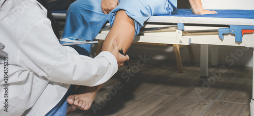 Female doctor examining her patient leg in hospital