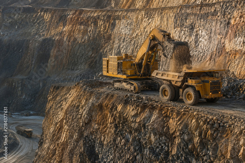 Excavator Loading Haul Truck on High Mine Bench