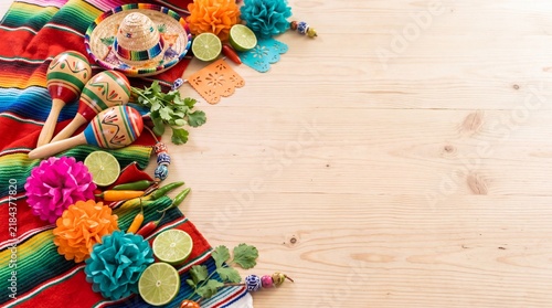 Mexican festival decorations and maracas on wooden background