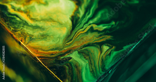 Ink splash. Neon pigment. Defocused green color triangle sparkling blend texture spilling on abstract acrylic background.