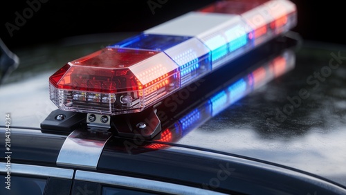 Police car emergency lights flashing on dark background
