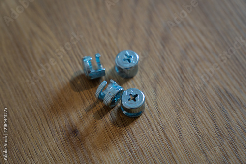 Metal cam lock furniture connectors on wooden surface