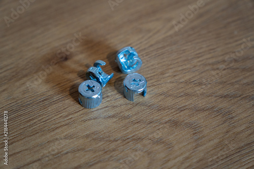 Metal cam lock furniture connectors on wooden surface