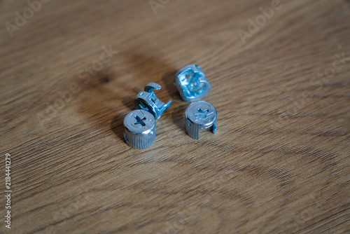 Metal cam lock furniture connectors on wooden surface
