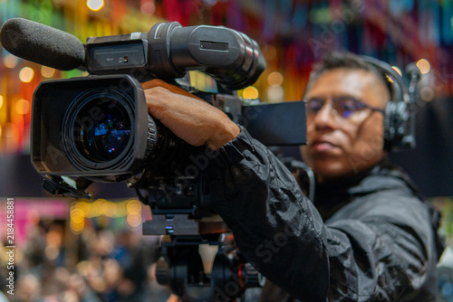 Cameraman recording live event with professional video camera